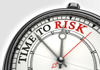 A handheld clock showing time to risk on the front